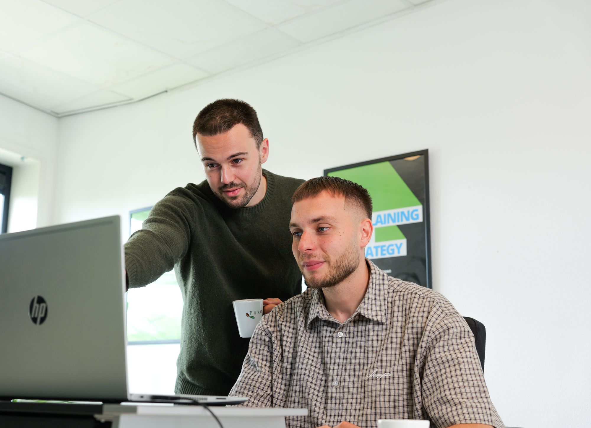 Twee specialisten van IQ Leads werken samen achter een laptop